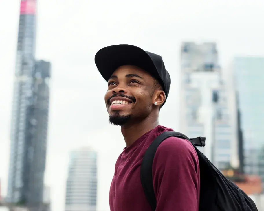 A traveller smiling in front of a city skyline after landing